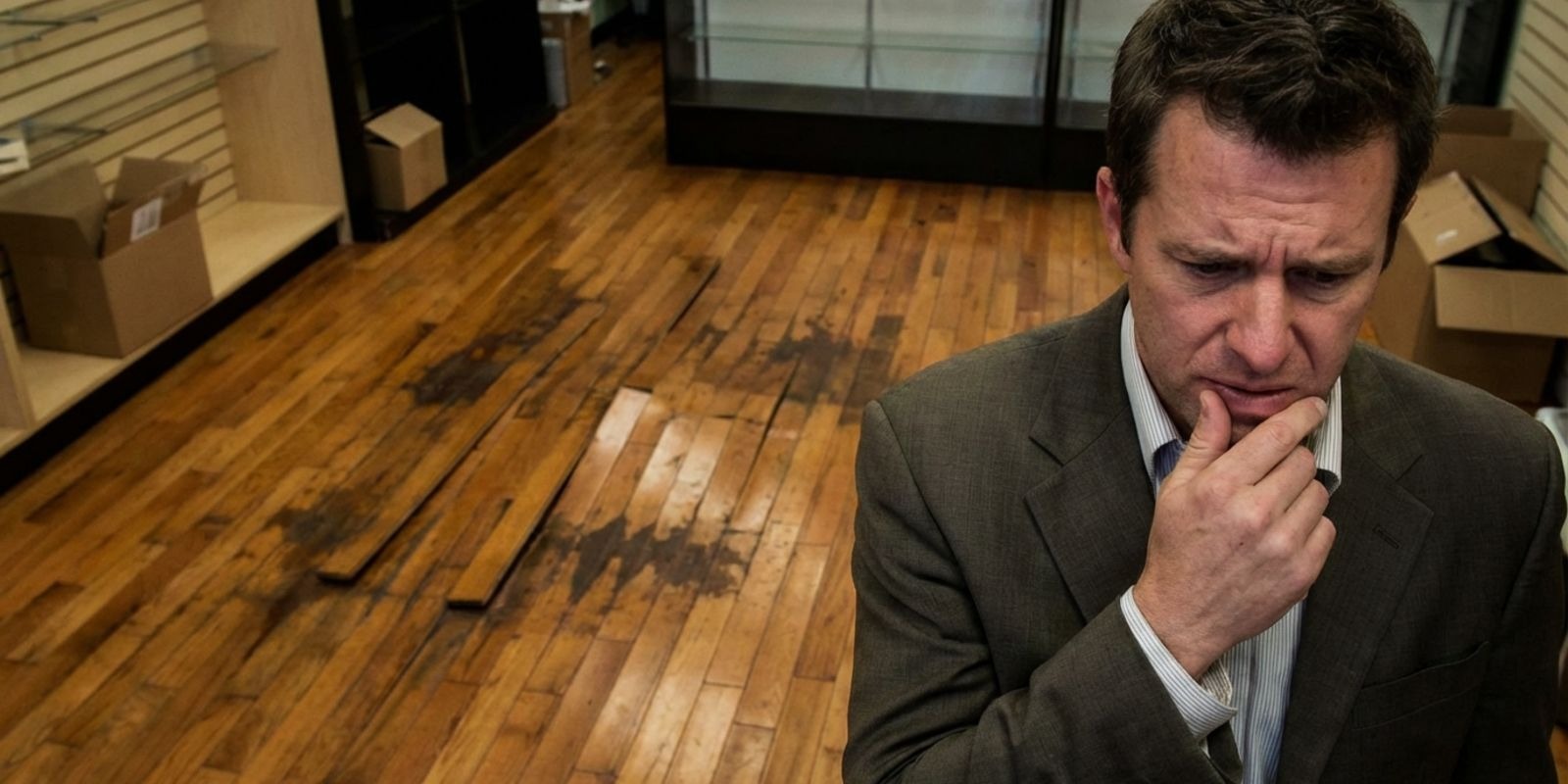 A man worried about the damaged hardwood floors in his property.