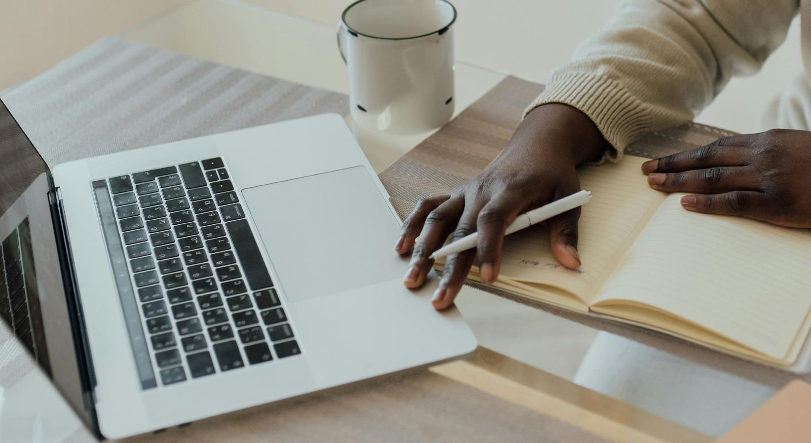A person documenting their insurance claim on paper and laptop.