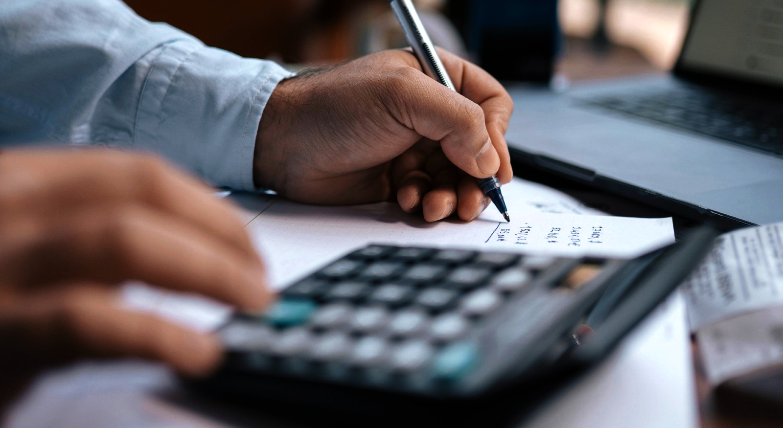 A close-up of a person calculating prices with a calculator.