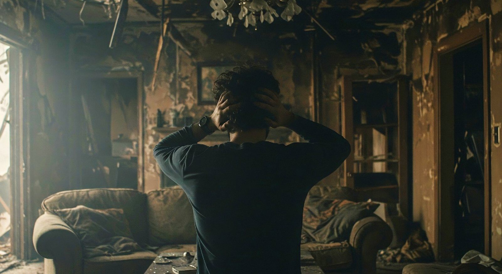 A person looking at fire damage in their living room.
