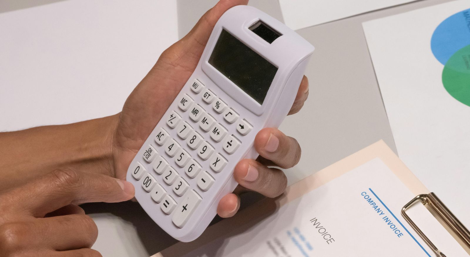 The hands of a person holding a calculator trying to make an estimate.
